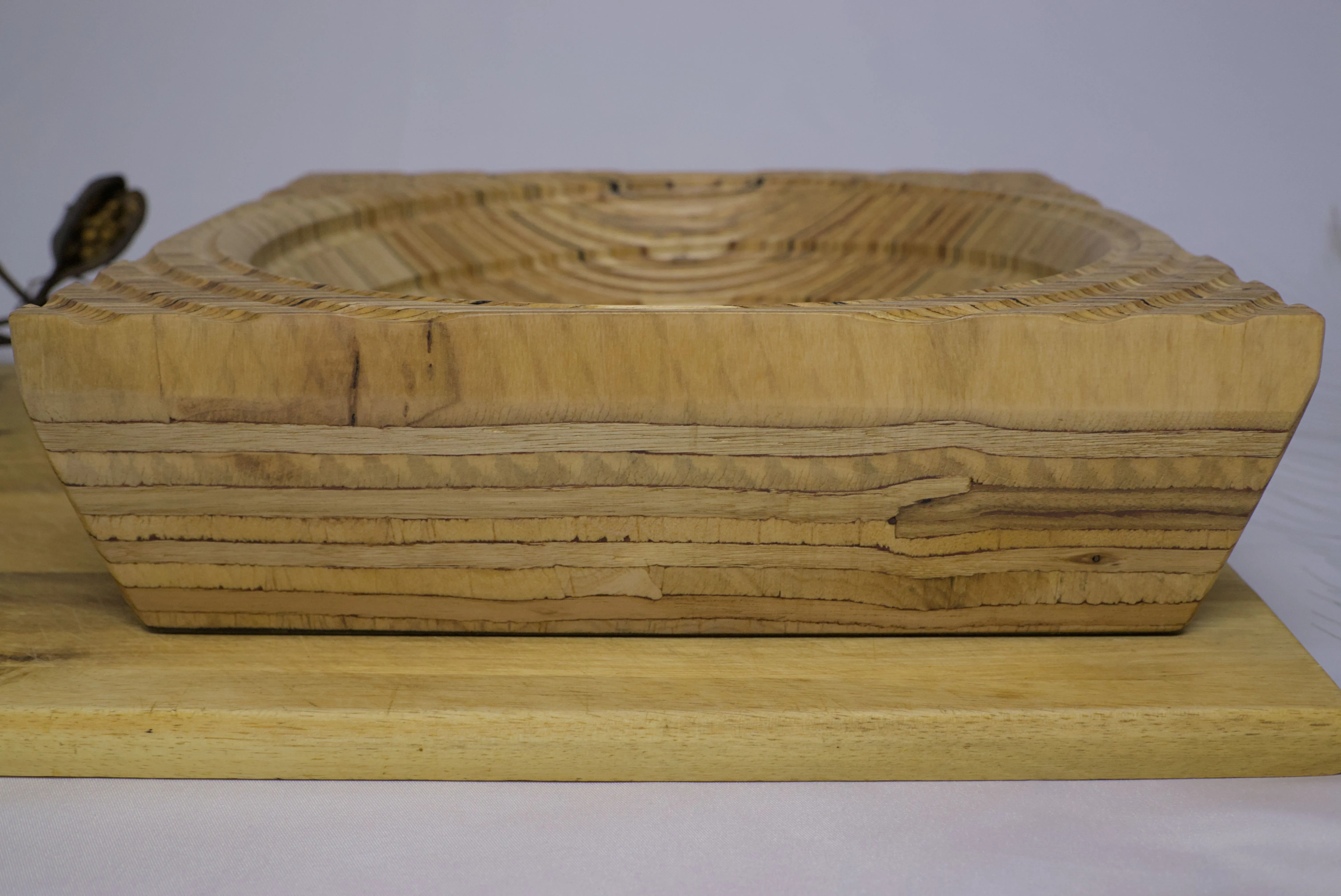 Side view of a plywood bowl with a groove spiralling towards the center