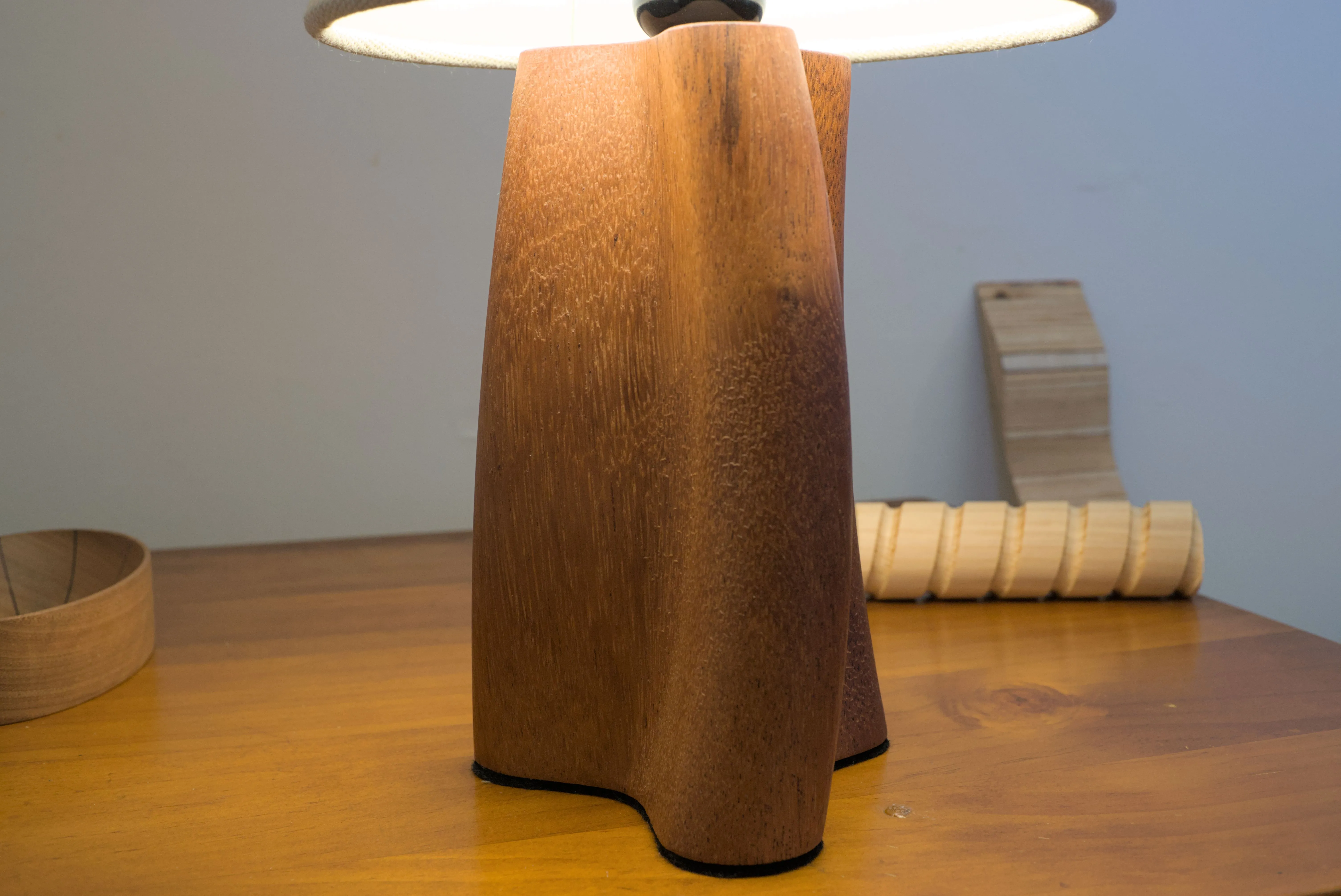 Underside view of a table lamp with a curving and twisting shape.